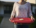 Woman holding container of food