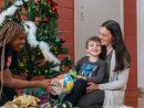 A mother being gioven a christmas gift by a salvos volunteer with her son 