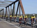 men-riding-bikes-across-bridge