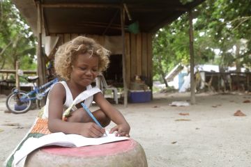 A girl writing outdoors