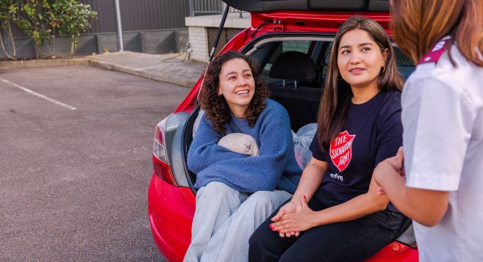 Salvos personnel and volunteer helping a woman living in a car.