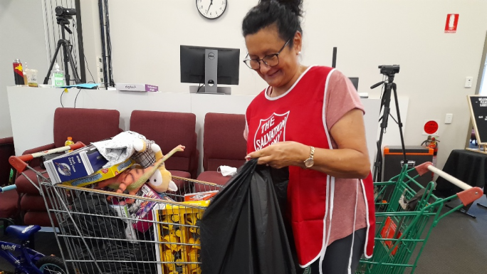 Lucy packing a bag of gifts while volunteering