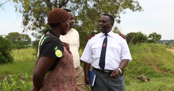 Salvo talking to couple in a field as part of the international development work in Asia, Africa and the Pacific. 