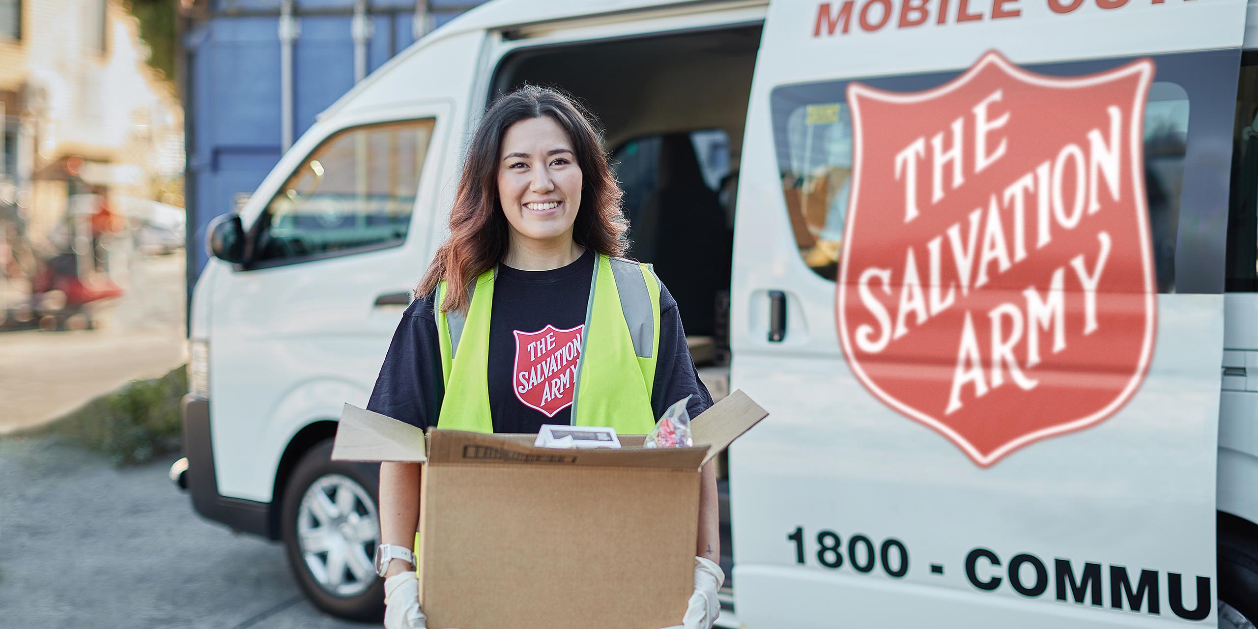 A Salvo volunteer holding a food hamper