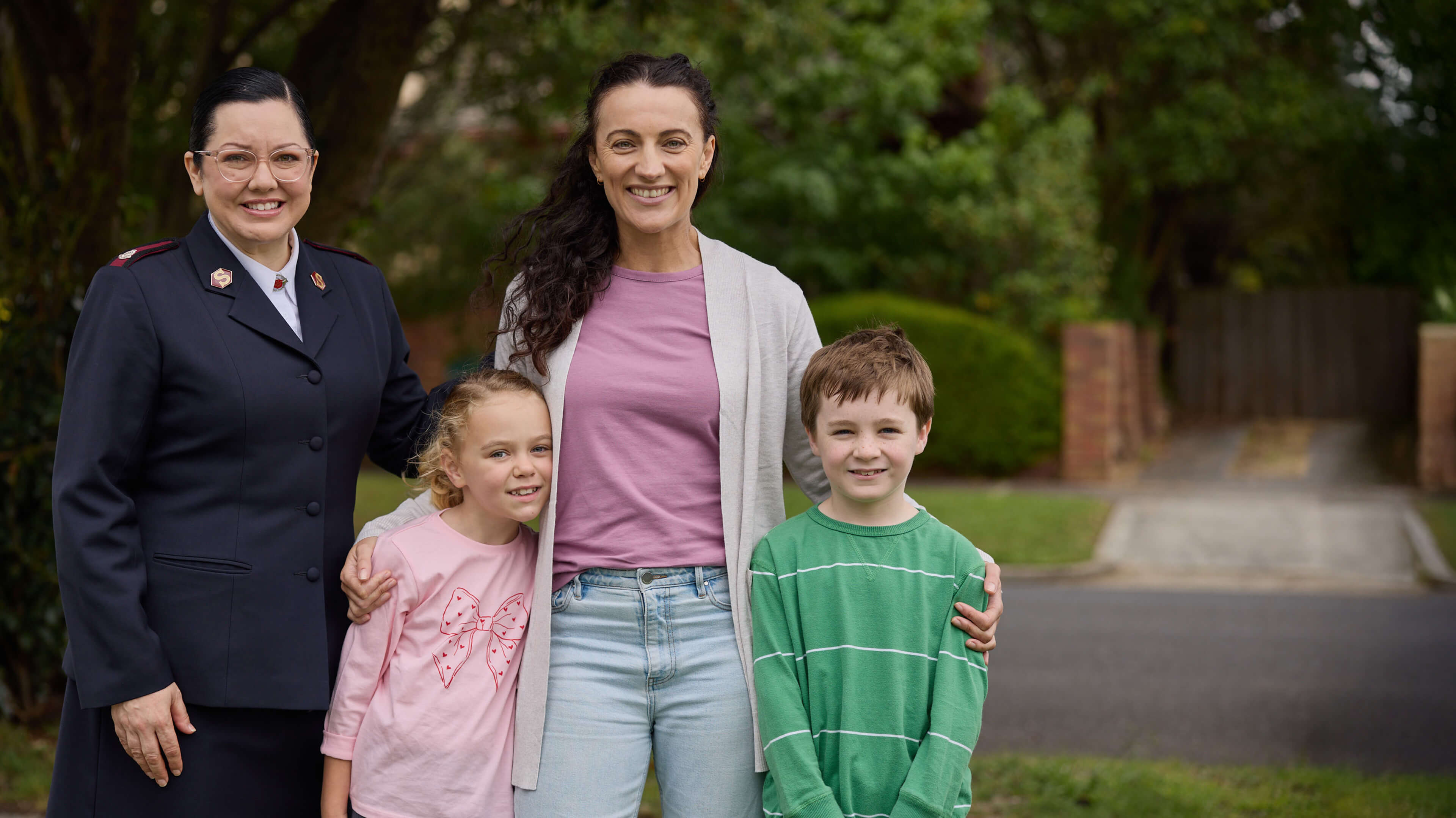 Salvos personnel standing next to a smiling family